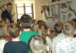Przedszkolaki oglądają narzędzia służące stolarzowi.